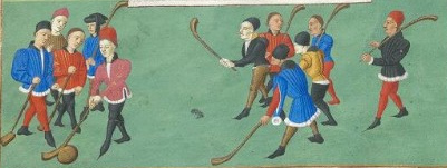 Men with wooden hockey-like sticks play with a ball on a green field